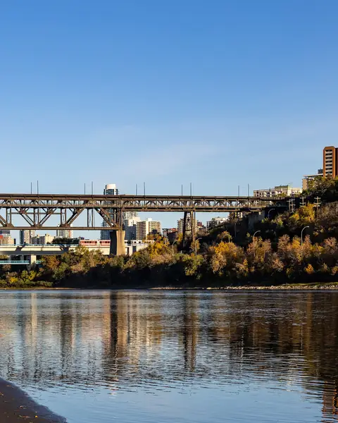 The High Level Bridge spanning the North Saskatchewan River with autumn trees reflected in the water