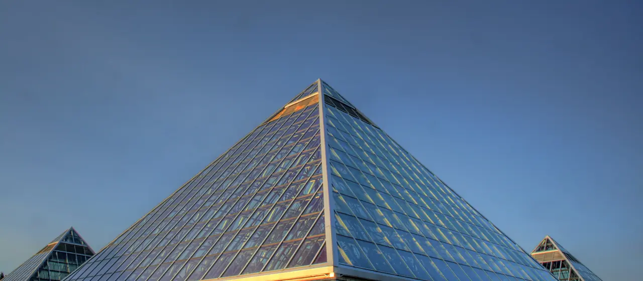 Glass pyramid of the Muttart Conservatory glowing in late-day light in Edmonton